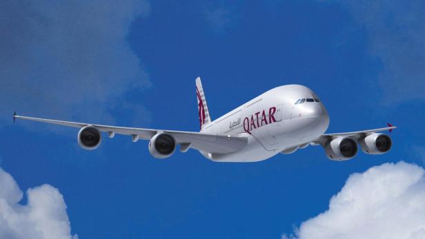Ein Qatar Airways Airbus A380 im Flug vor blauem Himmel.