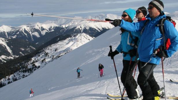 Eine Gruppe Skifahrer genießt die Aussicht auf die schneebedeckten Berge.
