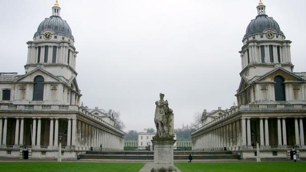 Das Old Royal Naval College in Greenwich mit einer Statue im Vordergrund.