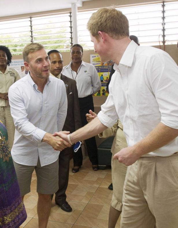 Prinz Harry schüttelt Gary Barlow die Hand.