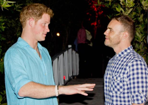 Prinz Harry unterhält sich mit Gary Barlow bei einer abendlichen Veranstaltung.