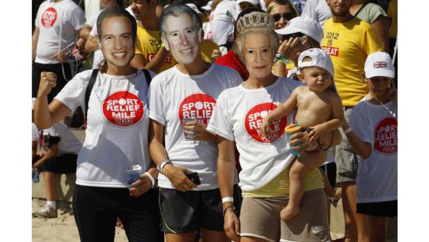 Menschen mit Masken von Mitgliedern der königlichen Familie nehmen an einem Wohltätigkeitslauf teil.