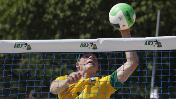 Ein brasilianischer Volleyballspieler schlägt den Ball über das Netz.