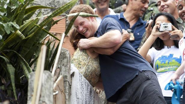 Prinz Harry umarmt eine Frau in einer Menschenmenge.