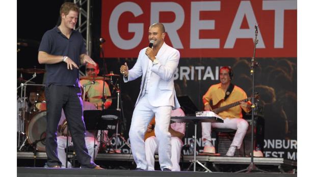 Prinz Harry und ein Sänger treten gemeinsam auf einer Bühne auf.