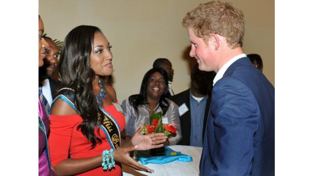 Prinz Harry spricht mit Miss Bahamas in einem formellen Rahmen.