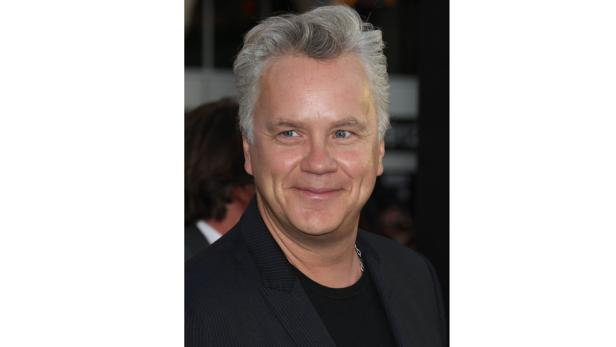 Tim Allen lächelt in einem dunklen Anzug.