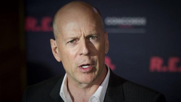 Porträt von Bruce Willis vor einem dunklen Hintergrund mit roter Schrift.