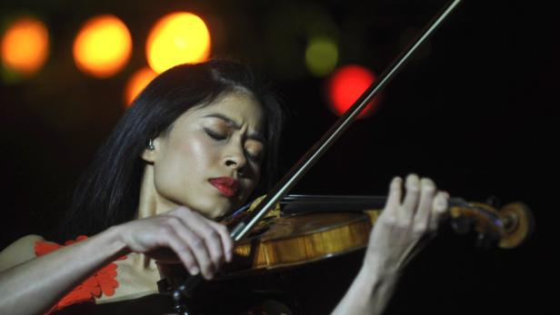 Eine Frau mit roten Lippen spielt auf einer Geige.