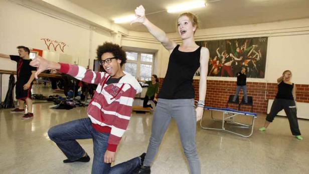 Eine Gruppe junger Leute tanzt und posiert in einem Tanzstudio.