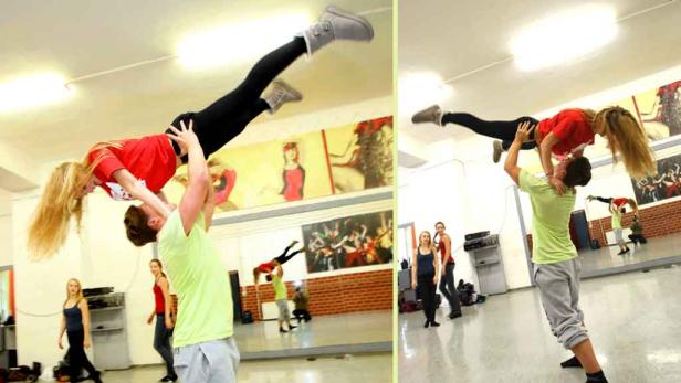 Ein Mann hebt eine Frau in einem Tanzstudio hoch.