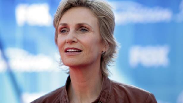 Jane Lynch lächelt vor einem blauen Hintergrund mit dem FOX-Logo.