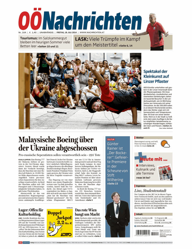 Ein Straßenkünstler zeigt eine akrobatische Darbietung vor Publikum in Linz.