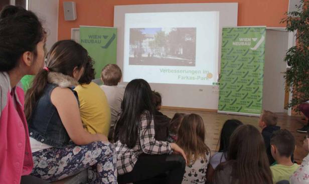 Eine Gruppe von Kindern schaut sich eine Präsentation über Verbesserungen im Farkas-Park an.