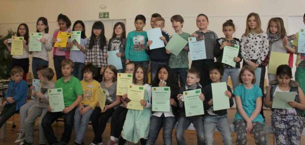 Eine Gruppe von Kindern hält Urkunden in den Händen.