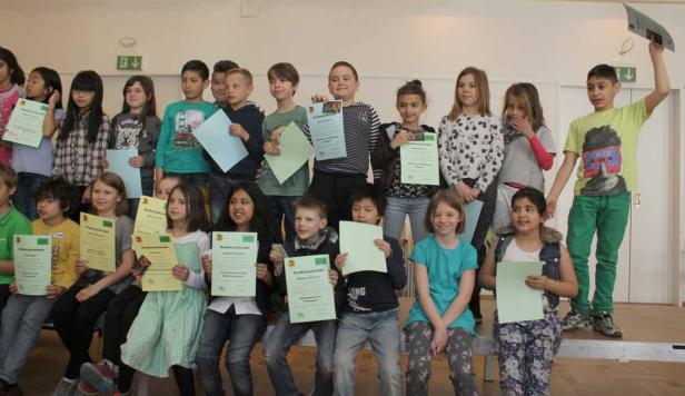 Eine Gruppe von Kindern hält Urkunden in den Händen.