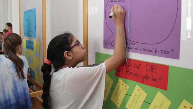 Ein Mädchen schreibt auf ein lila Plakat mit der Frage: „Was hat DIR am Besten gefallen?“.