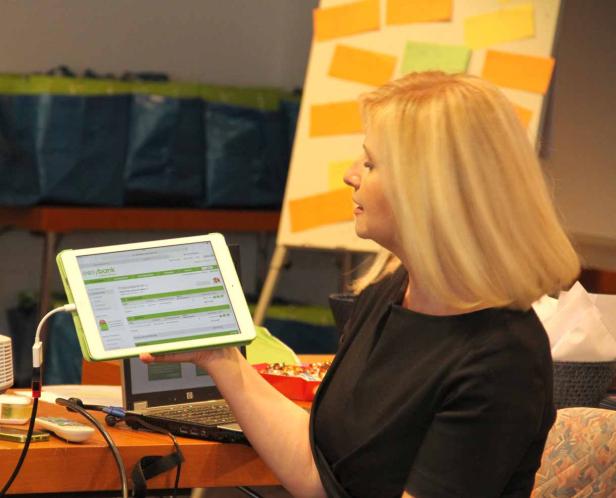 Eine Frau hält ein Tablet mit der Webseite von Easybank in der Hand.