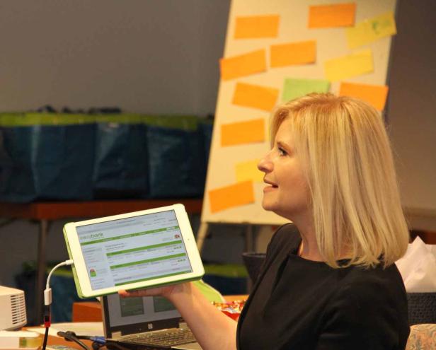 Eine Frau präsentiert ein Tablet mit der Webseite von Easybank.