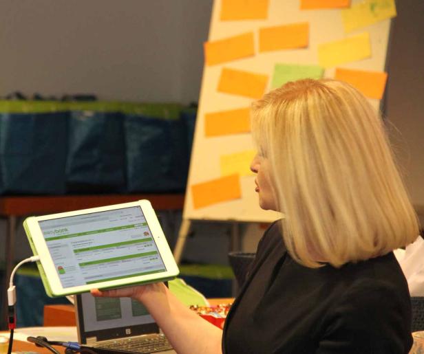 Eine Frau präsentiert ein Tablet mit der Webseite von Easybank.