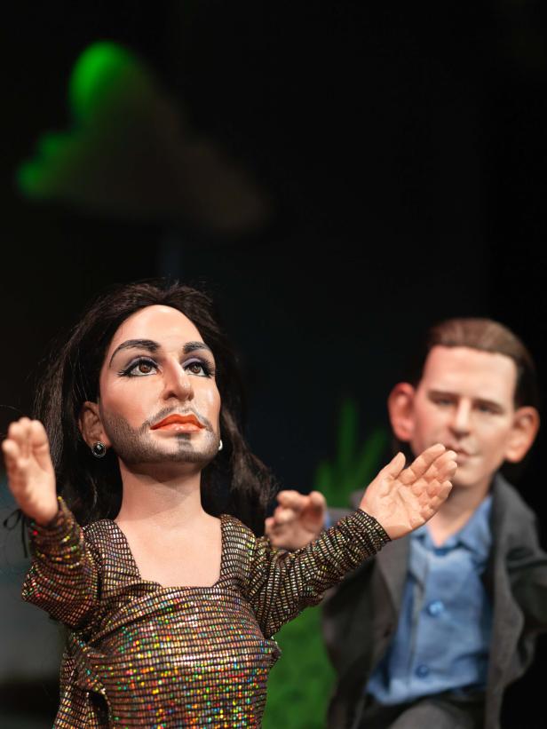 Eine Hexe und Conchita Wurst als Puppenkönigin im Politiker-Kasperltheater