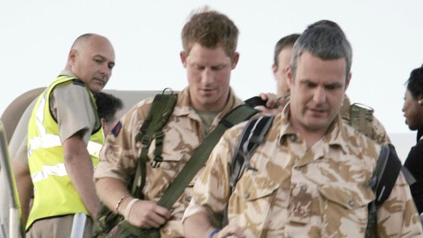 Prinz Harry in Militärkleidung steigt eine Flugzeugtreppe hinunter.