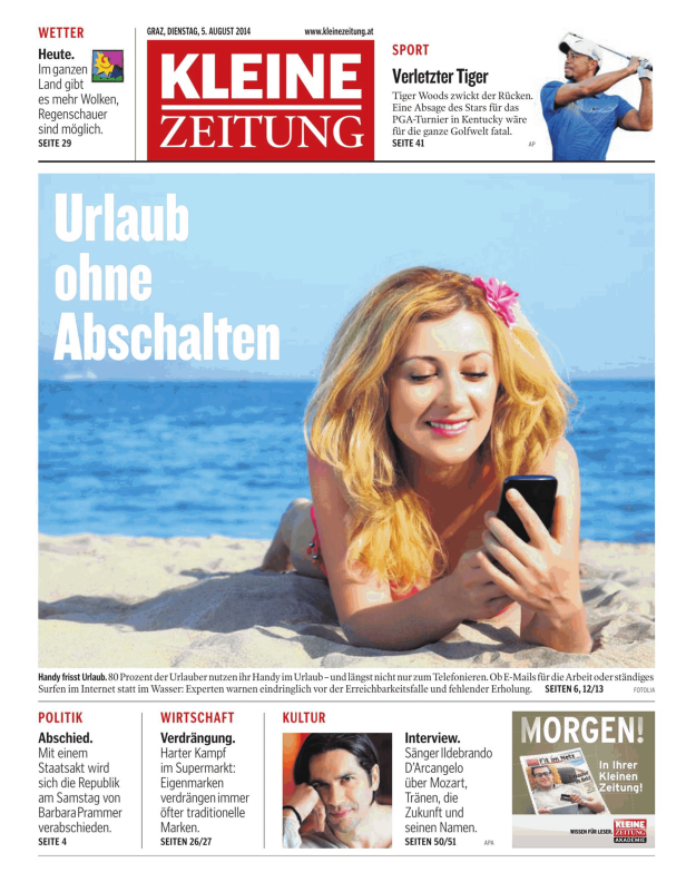 Eine Frau liegt am Strand und benutzt ihr Smartphone.