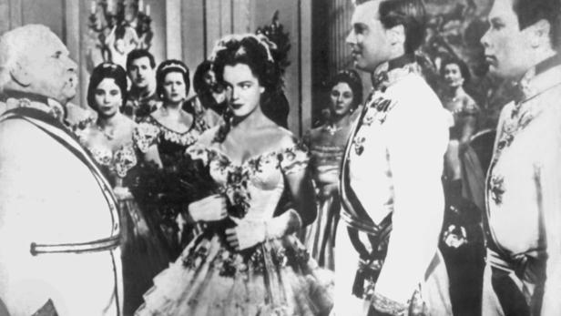 Szene mit Romy Schneider als Sissi, umgeben von Hofbeamten.