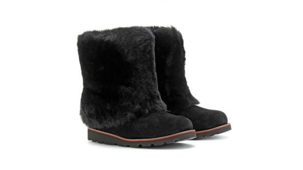 Ein Paar schwarze Winterstiefel mit Fellbesatz stehen vor einem weißen Hintergrund.