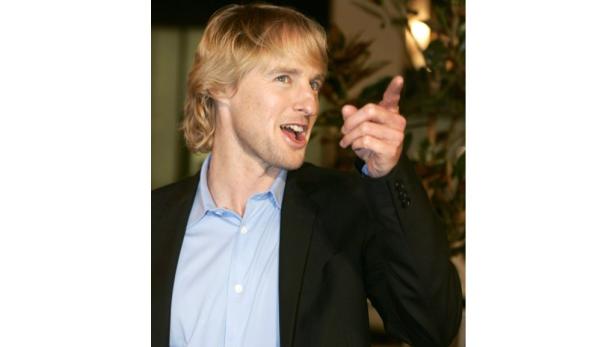 Owen Wilson zeigt mit dem Finger nach rechts.