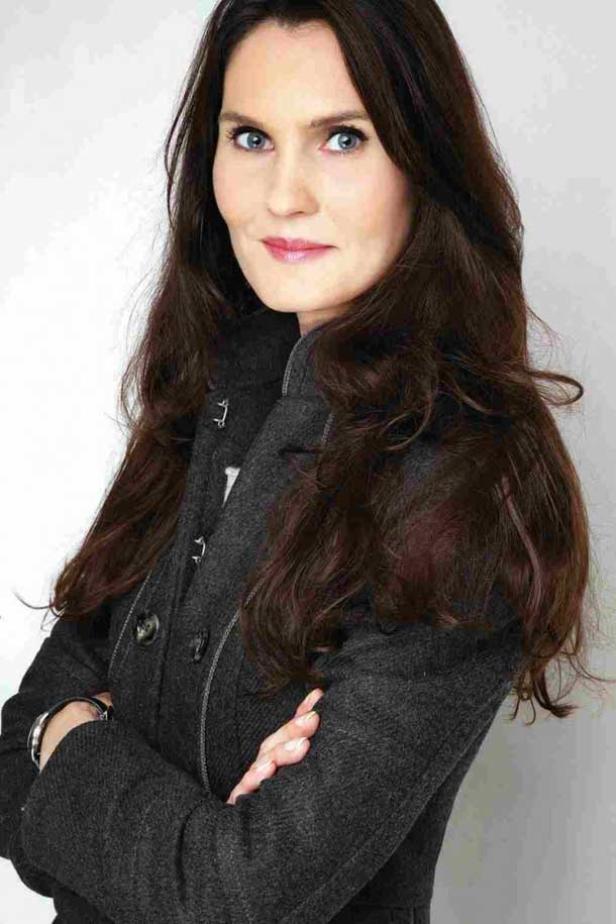 Daniela Schuster (C: Styria Multi Media Ladies) Eine Frau mit braunen Haaren und blauem Blick trägt einen grauen Mantel und verschränkt die Arme.