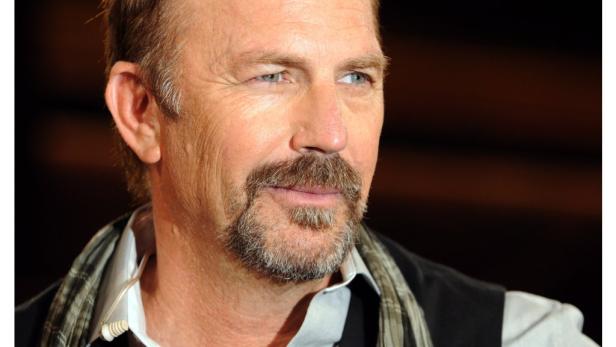 Porträt von Kevin Costner mit Bart und hellblauen Augen.