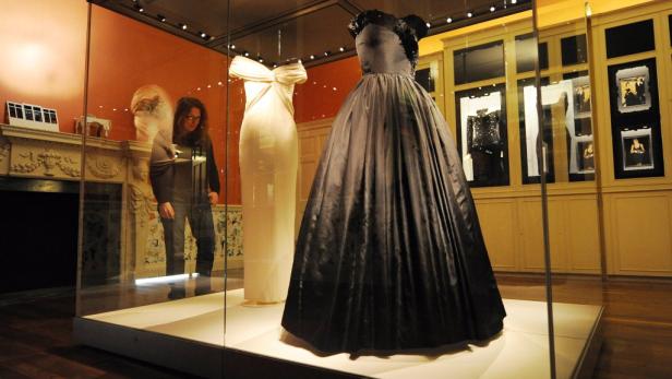 Zwei Kleider von Prinzessin Diana sind in einer Vitrine ausgestellt.