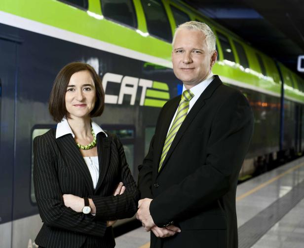 Zwei Personen stehen vor einem CAT-Zug.