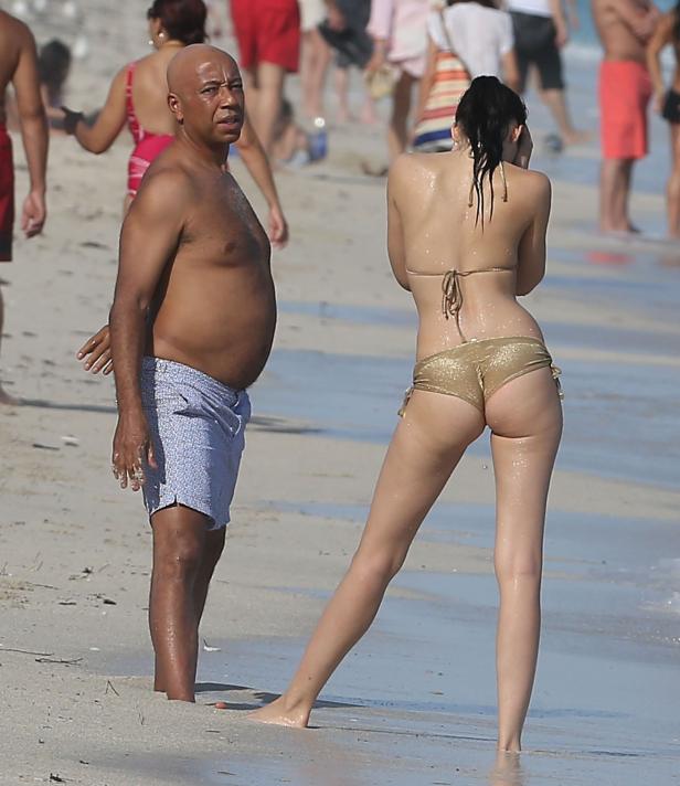 Ein Mann und eine Frau stehen am Strand, umgeben von anderen Badegästen.