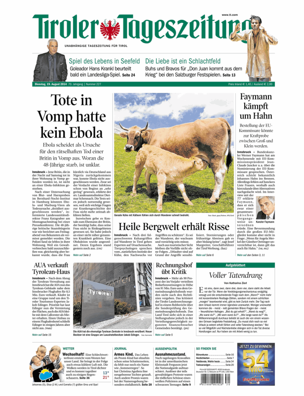 Eine Kuh mit ihrem Kalb auf einer grünen Wiese in Tirol.