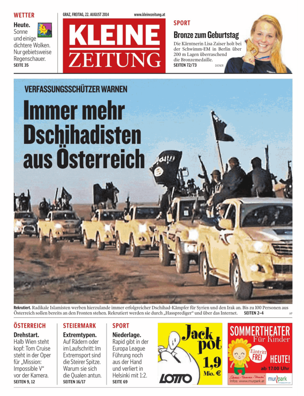 Mehrere mit Kämpfern besetzte Pickups mit Dschihadistenflaggen in einer Wüstenlandschaft.