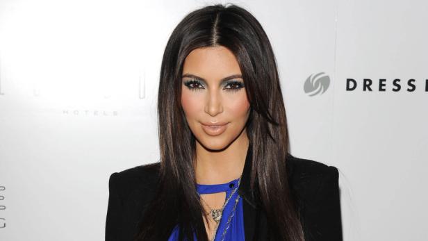 Ein Porträt von Kim Kardashian mit dunklen Haaren und blauem Oberteil.