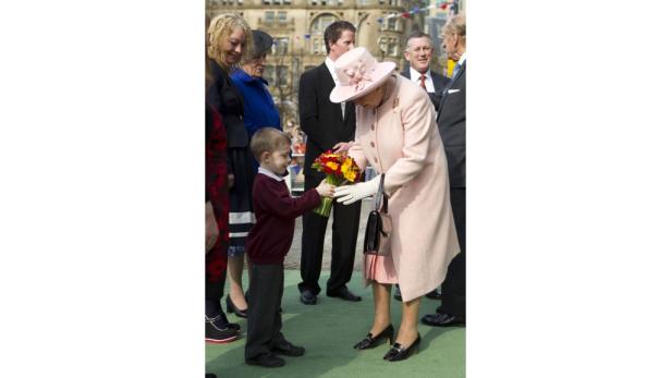 Ein Junge überreicht Königin Elisabeth II. einen Blumenstrauß.