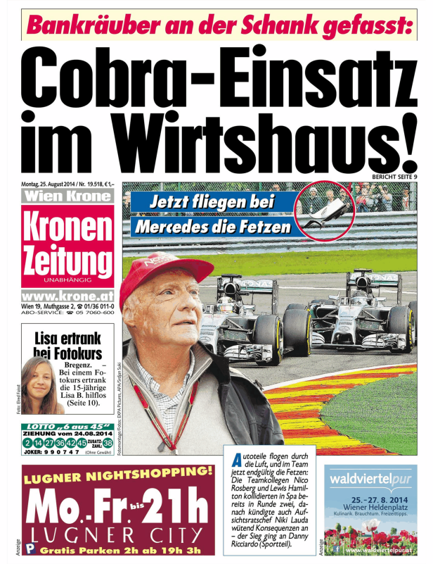 Niki Lauda vor zwei Formel-1-Wagen auf einer Rennstrecke.