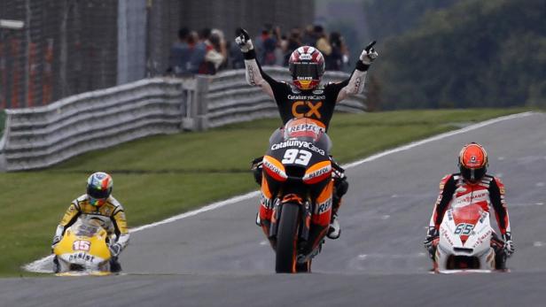 Marc Márquez feiert seinen Sieg, während andere Fahrer im Kiesbett stehen.