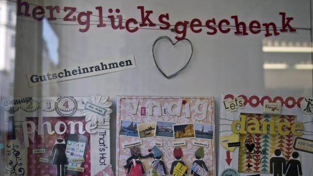 Ein Schaufenster mit Dekorationen und Schriftzügen wie „herzglücksgeschenk“ und „Gutscheinrahmen“.