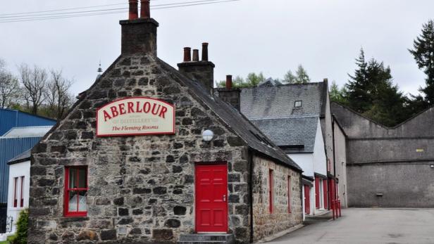 Das Aberlour Distillery Gebäude mit roter Tür und Fensterrahmen.