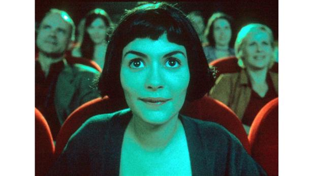 Audrey Tautou sitzt im Kino und schaut aufmerksam auf die Leinwand.