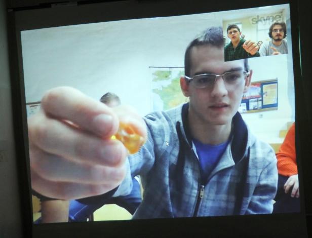 Ein junger Mann zeigt während eines Skype-Anrufs ein Bonbon in die Kamera.