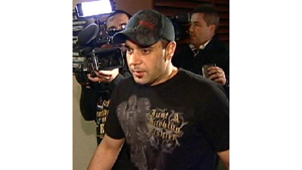 Ein Mann wird von Kameraleuten umringt.