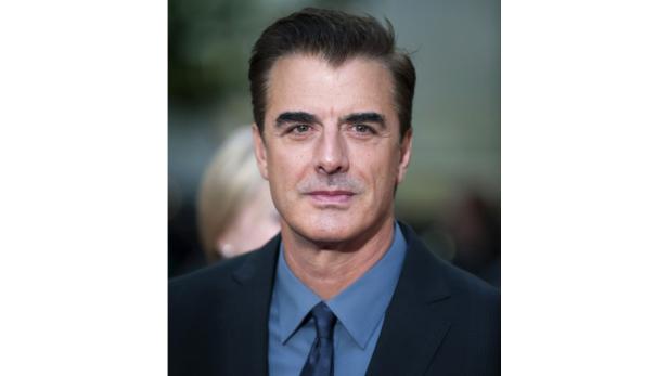 Porträt von Chris Noth, der eine blaue Krawatte und ein blaues Hemd unter einem dunklen Anzug trägt.