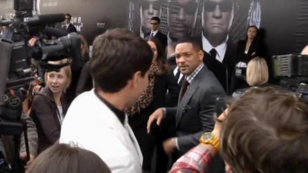 Will Smith posiert auf dem roten Teppich für Fotografen.