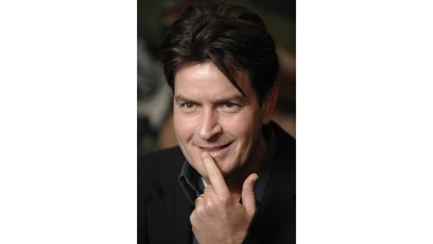 Porträt von Charlie Sheen, der seinen Finger an die Lippe hält.