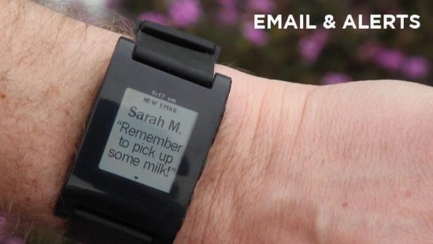 Eine Smartwatch am Handgelenk zeigt eine E-Mail-Benachrichtigung von Sarah M. an, die an den Kauf von Milch erinnert.
